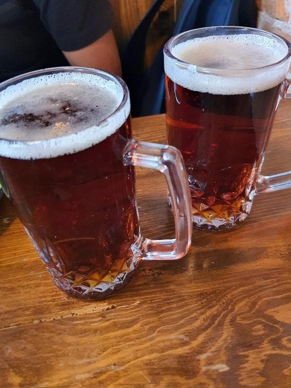 Dos tarros de cerveza sobre mesa de madera