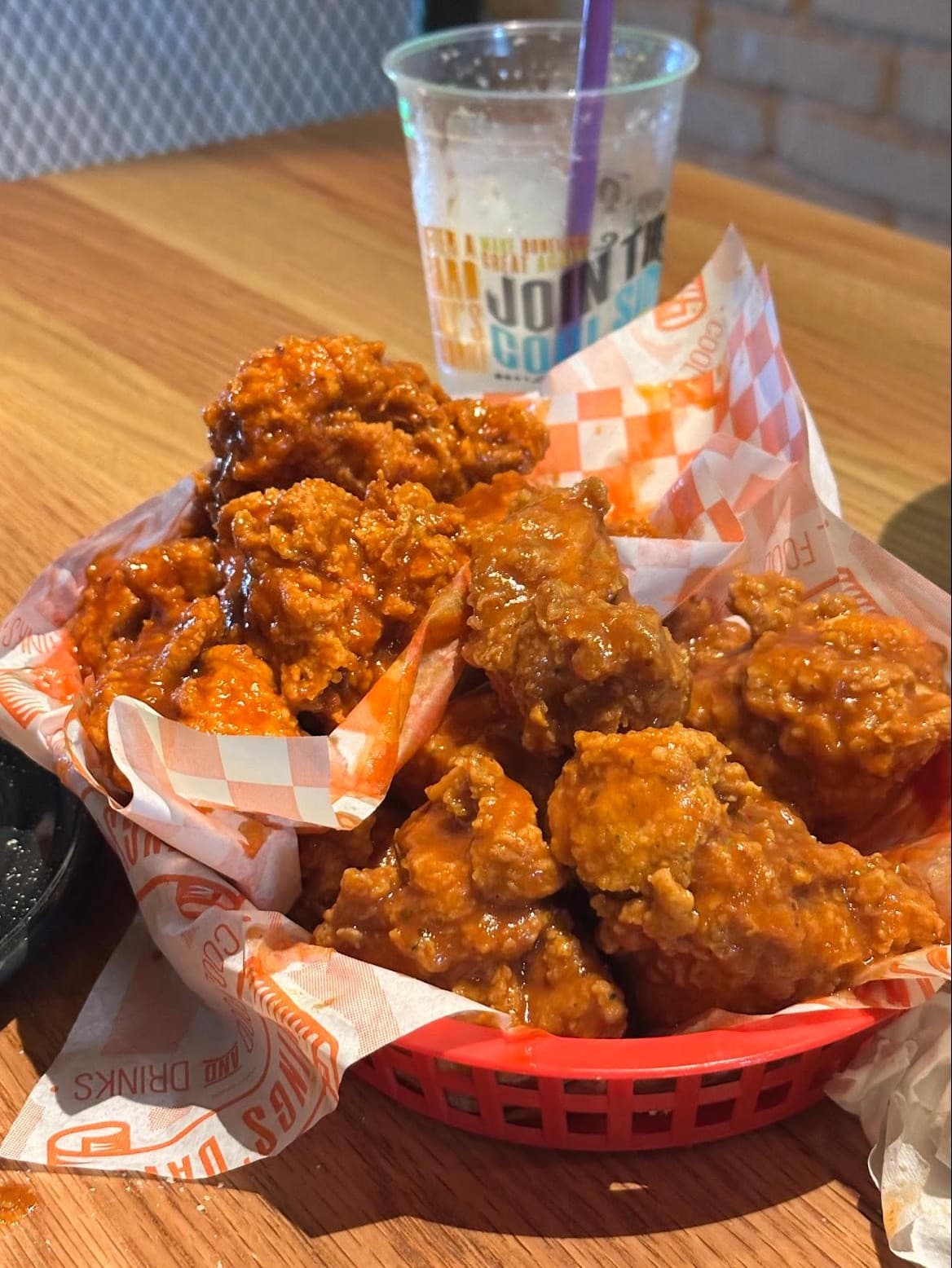 Canasta de boneless búfalo con papel de marca y vaso Wings' Davo