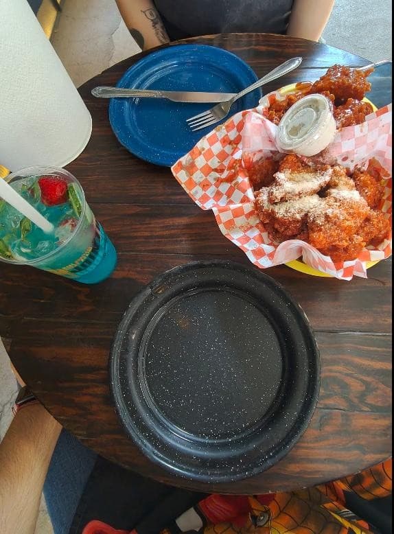 Boneless parmesano y cóctel azul sobre la mesa