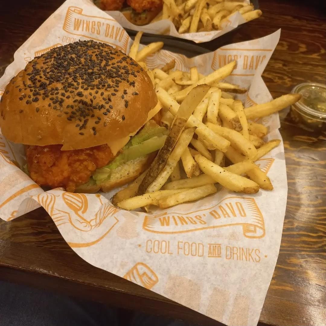 Hamburguesa de pollo con papas sobre papel Wings' Davo