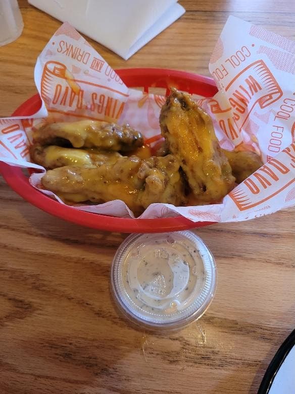 Alitas mango habanero en canasta roja con ranch